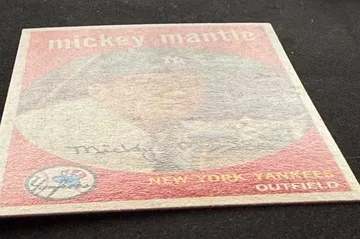 1959 Topps Mickey Mantle tilted under light to reveal surface wear